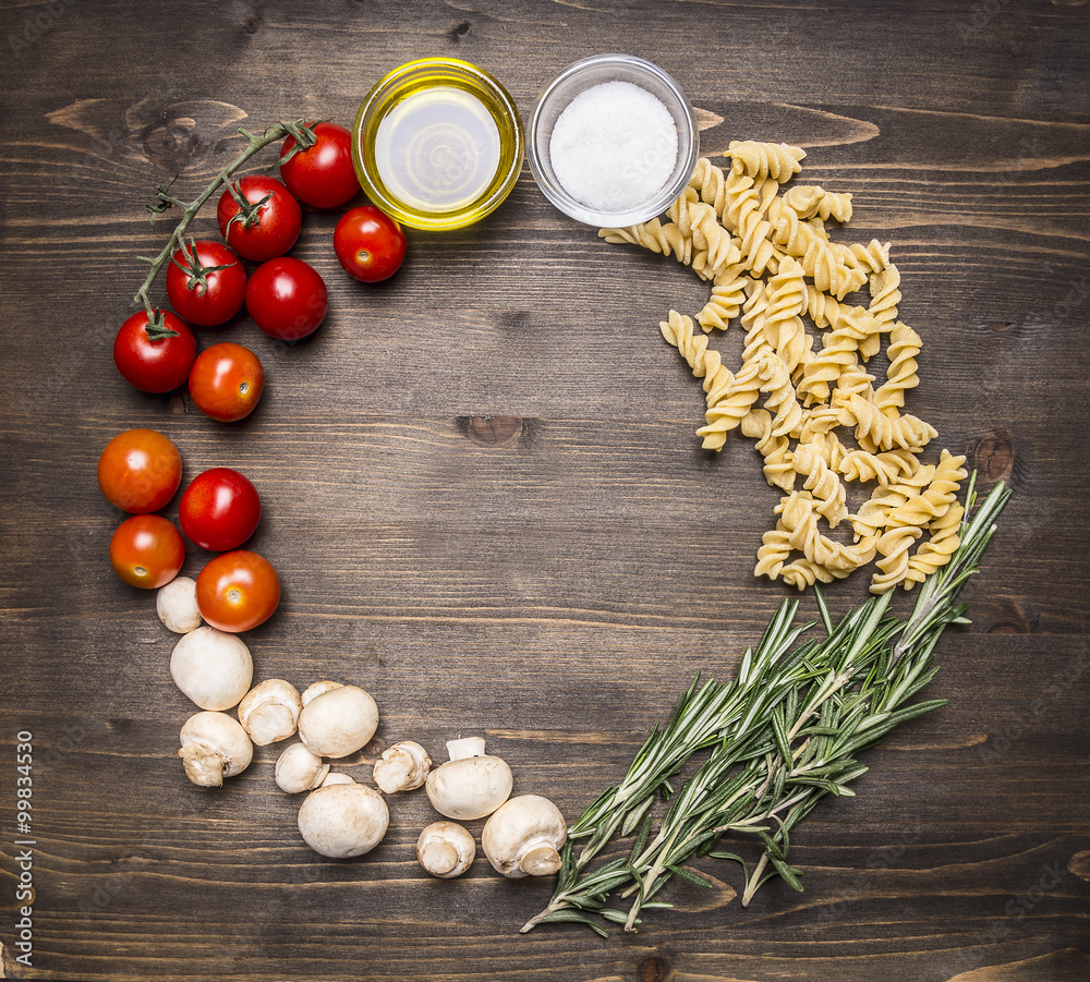 Ingredients for cooking vegetarian raw fusilli pasta with sunflower oil cherry tomatoes, mushrooms, rosemary place for text,frame on wooden rustic background top view Ingredients for cooking vegetarian raw fusilli pasta with sunflower oil cherry tomatoes, mushrooms, rosemary place for text,frame on wooden rustic background top view