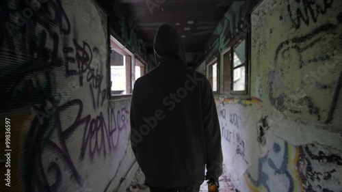 Slow motion of a bum walking in an abandoned house