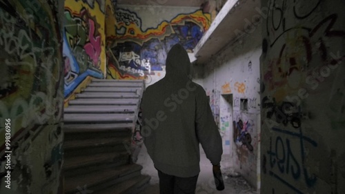 Slow motion of a bum walking in an abandoned house