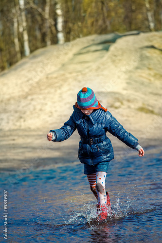 Fototapeta Naklejka Na Ścianę i Meble -  Girl running and jumping in puddle
