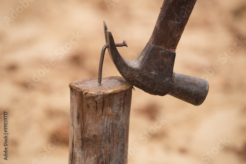 hammer pulling a nail out of wood