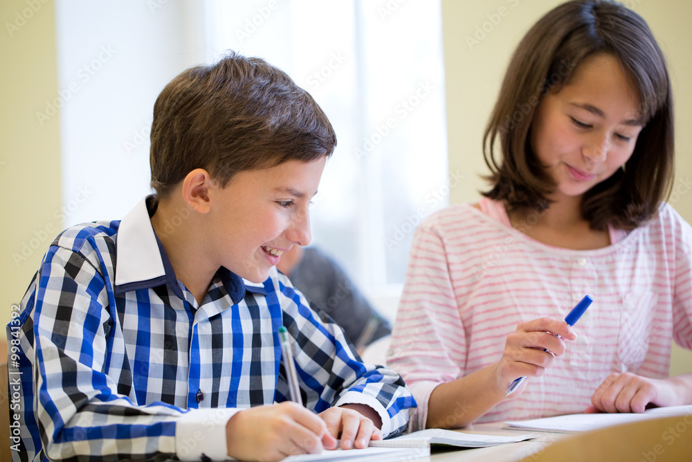 group of school kids writing test in classroom group of school kids writing test in classroom