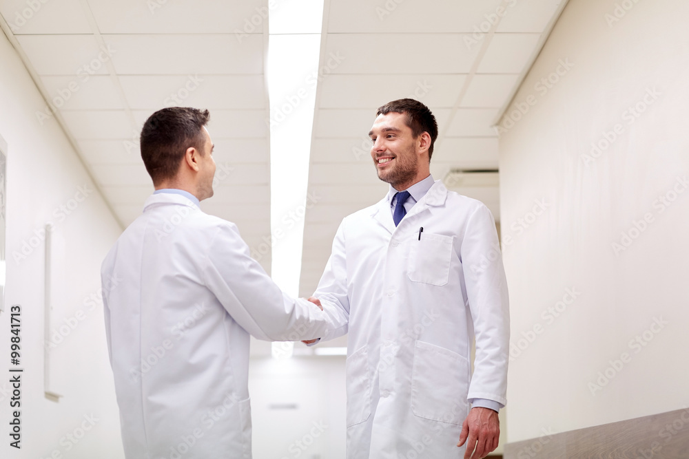 smiling doctors at hospital doing handshake smiling doctors at hospital doing handshake