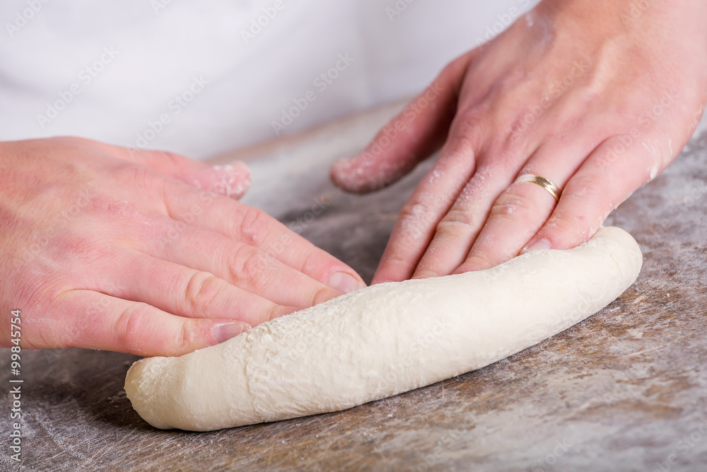 Close-up the hand of a baker kneading and shaping dough Close-up the hand of a baker kneading and shaping dough