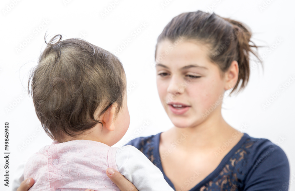 pretty girl playing with a baby on white background pretty girl playing with a baby on white background