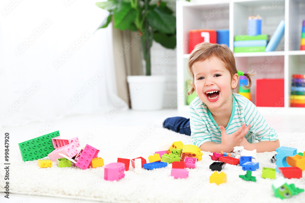 Fototapeta premium happy child laughing and playing with toys constructor