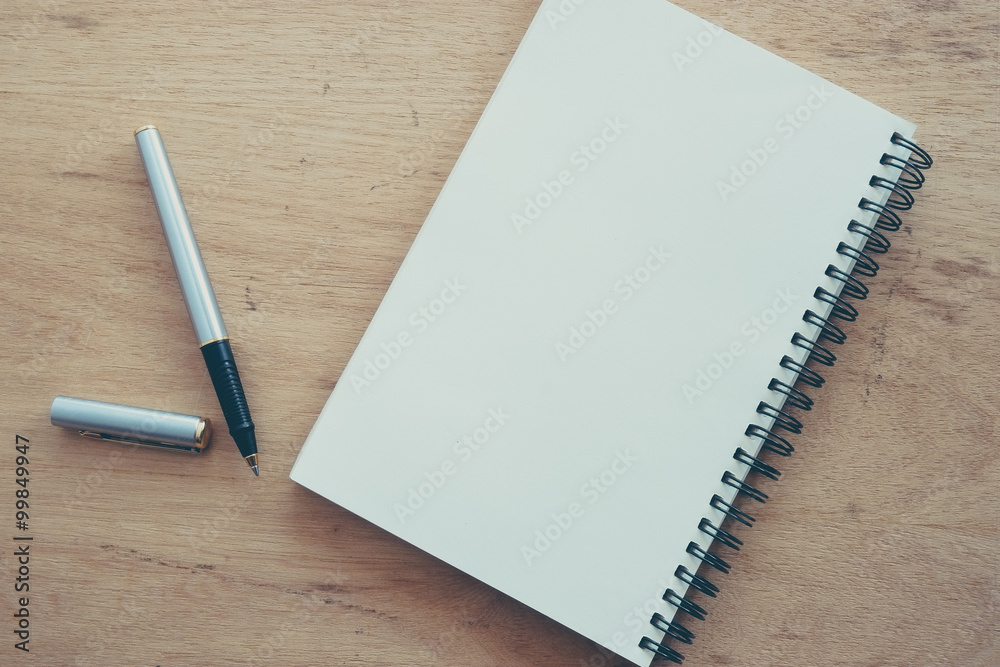 paper notebook and pen on a table with filter effect retro vinta paper notebook and pen on a table with filter effect retro vinta
