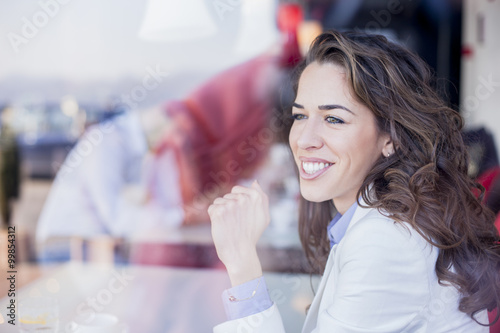 Free Download Business woman sitting next to window in coffee shop,working on her lap top. Shallow depth of field - GFXLoad