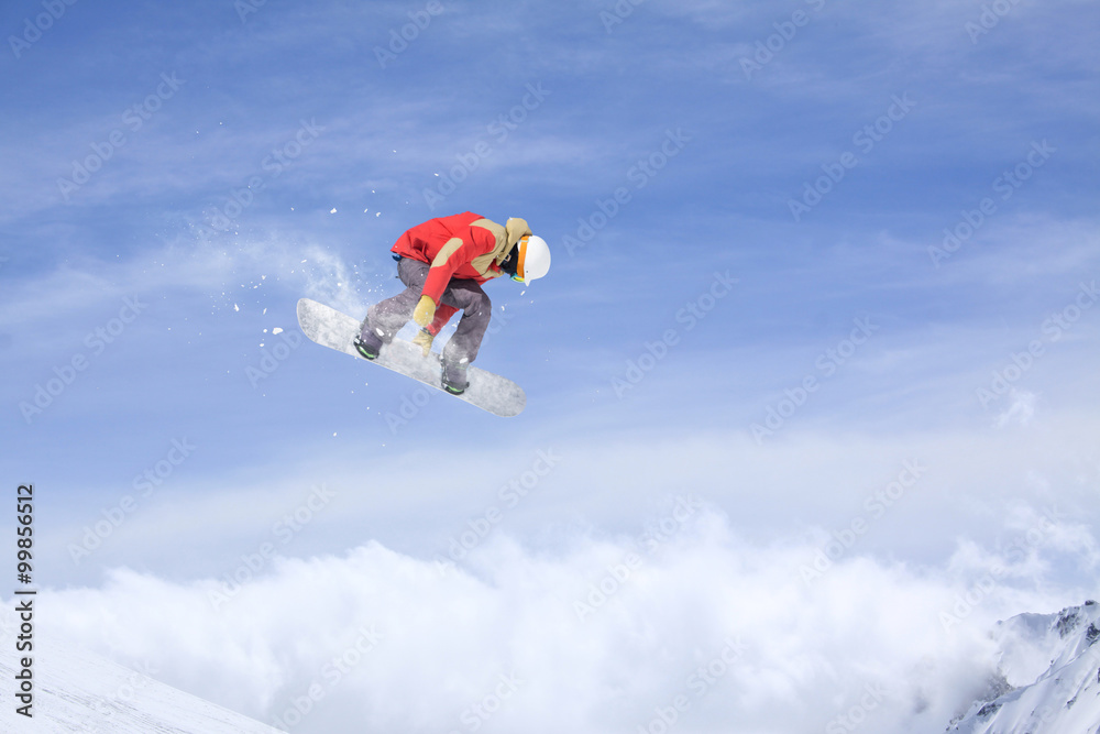 Flying snowboarder on mountains. Extreme sport.