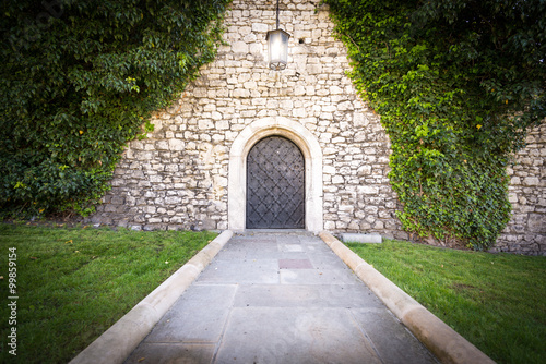 Small door at stone wall of old castle. photo