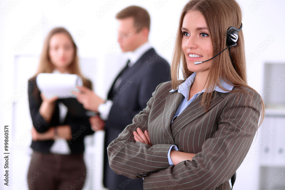 Portrait of beautiful cheerful smiling call operator on the background of business people. Successful call center concept