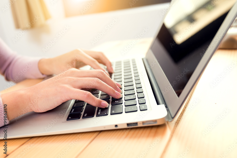 Woman typing report on notebok computer Woman typing report on notebok computer