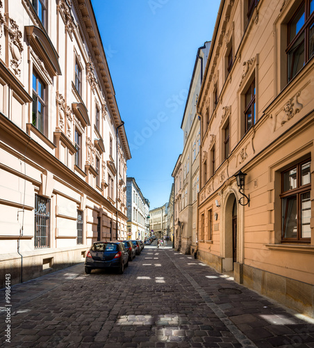 Narrow empty street with parked cars in Krakow  Poland.