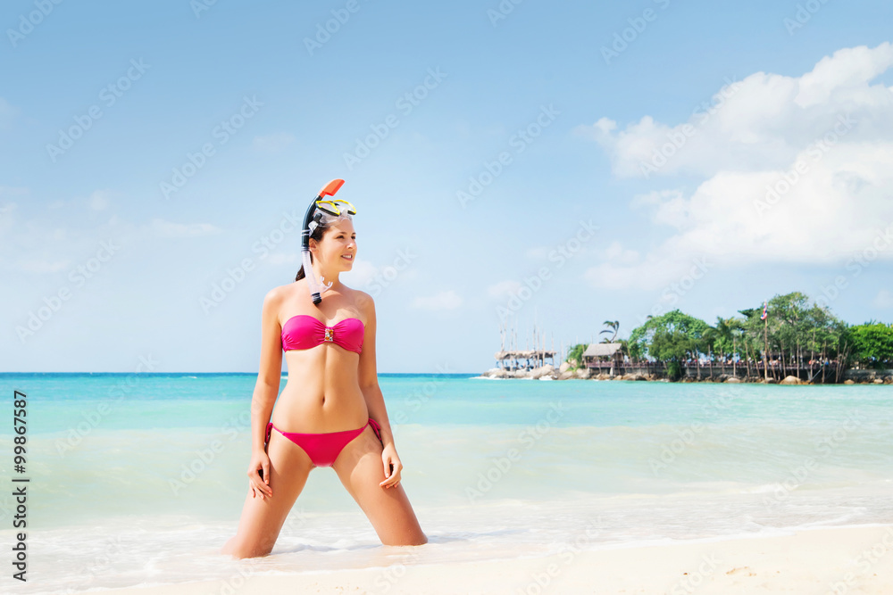 Beautiful, seductive woman in alluring swimwear posing on knees on the seacoast in Thailand. Beautiful, seductive woman in alluring swimwear posing on knees on the seacoast in Thailand.