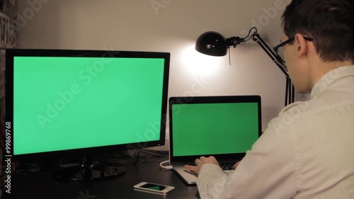 Man hands typing on green screen laptop computer photo