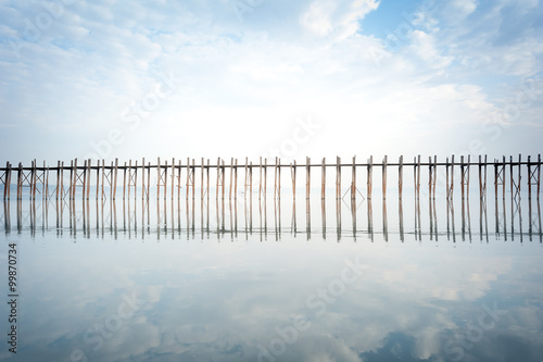 Tranquil and calm photography of peace and silence landscape of wooden bridge on lake with sky reflection