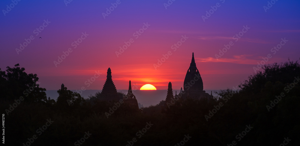 Fototapeta premium Ancient historical site Bagan in Myanmar at majestic sunset with beautiful sky and sun disk