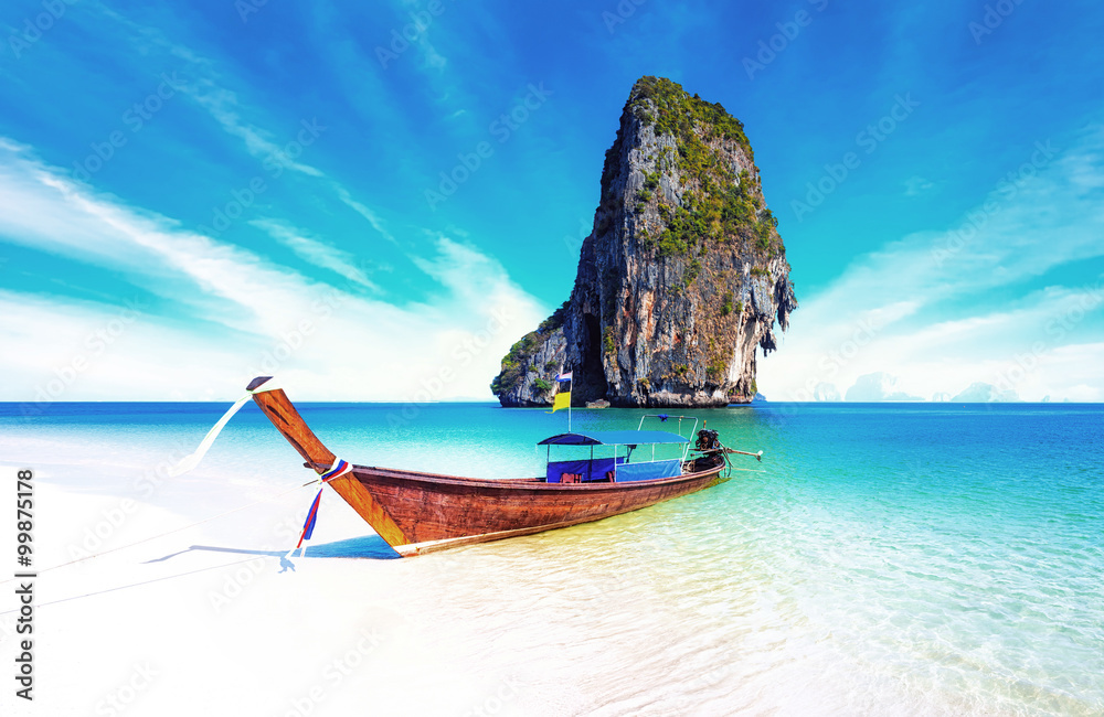 Sand beach on sea coast of tropical island in Thailand at sunny summer day with blue sky and clear water. Holiday vacation background