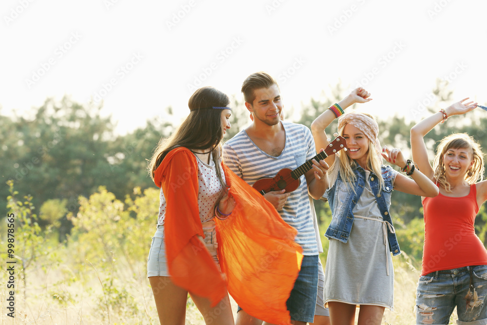 Fototapeta premium Joyful smiling friends dancing in the forest outdoors