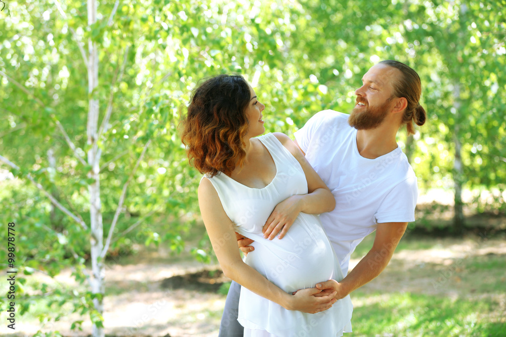 Together in waiting of baby's birth - happy man and woman in the park Together in waiting of baby's birth - happy man and woman in the park