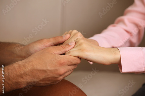 Concept of support - man and woman holding hands in the room