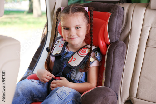 Cute little girl sitting in...