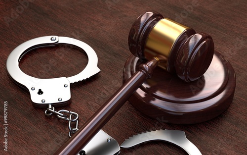  Gavel and handcuffs on wooden table background