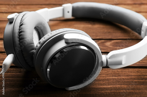 Headphones on brown wooden background © Africa Studio