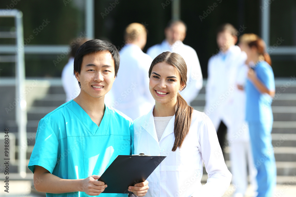 Medical concept - two doctors with stethoscopes and prescription clipboard Medical concept - two doctors with stethoscopes and prescription clipboard