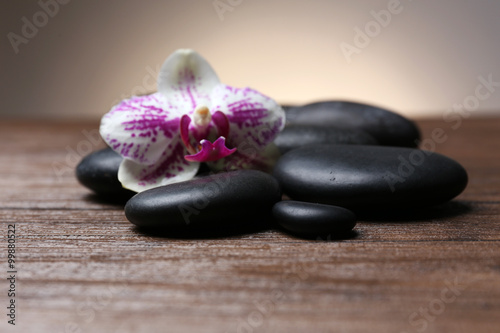 Black pebbles with orchid on wooden table