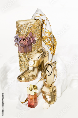 Sexy fashionable shoes with handbag and golden jewelry on white