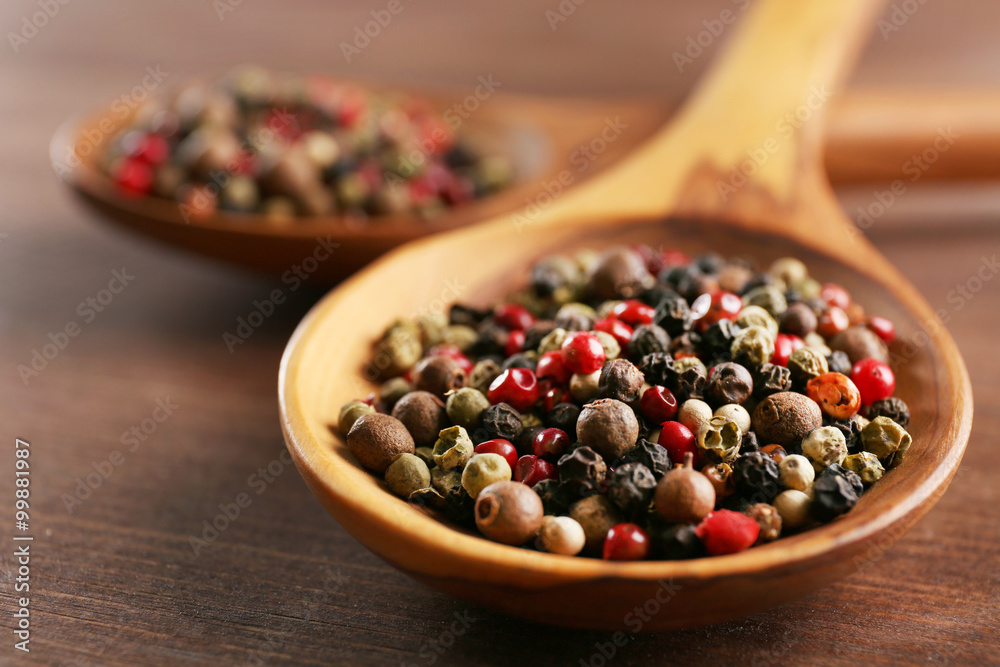 Pepper in wooden spoon on the table, close-up Pepper in wooden spoon on the table, close-up