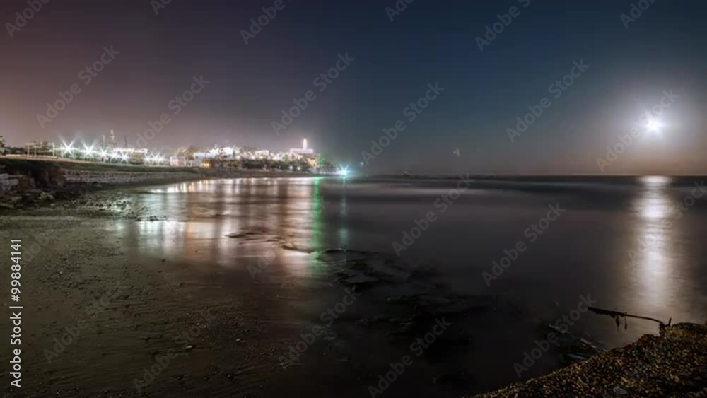 Moon setting into the ocean near an Israeli city Moon setting into the ocean near an Israeli city
