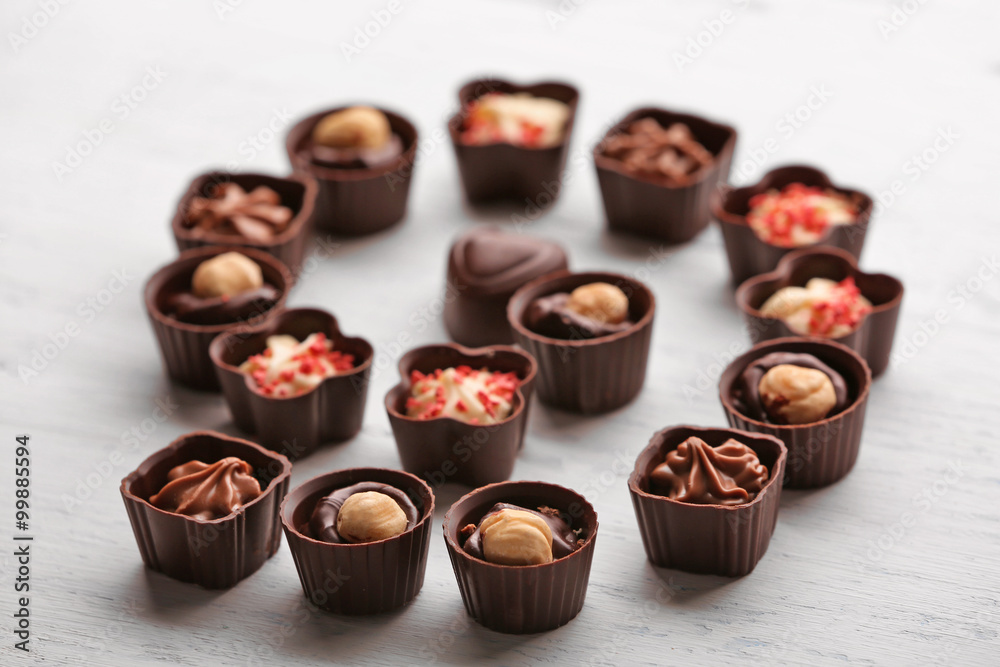 Set of chocolate candies on a light wooden background, close up