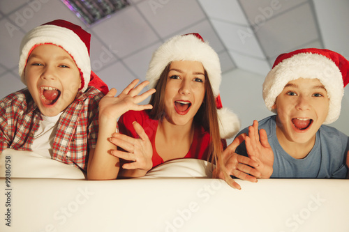 Cheerful children on sofa in decorated Christmas room, close up