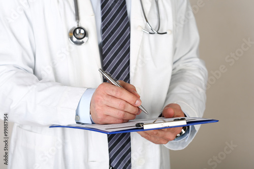 Male medicine doctor hand holding silver pen writing something o