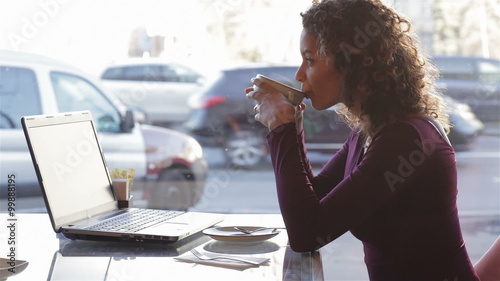 Cute girl drinking coffee on a cafe in the city photo