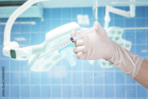 Woman Doctor holding syringe on surgical room background