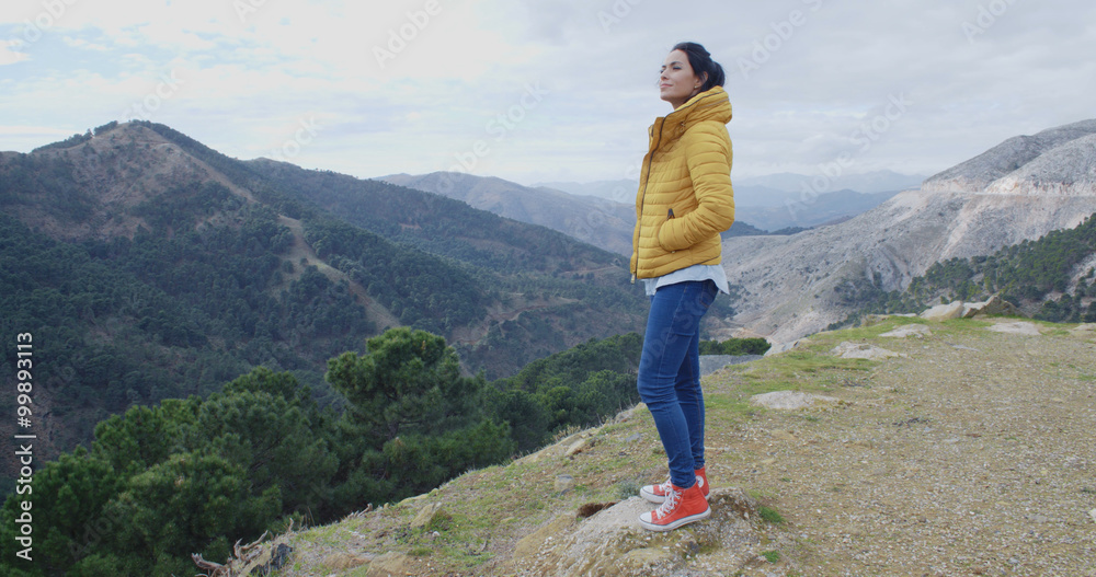 Obraz premium Woman in yellow coat near mountain valley