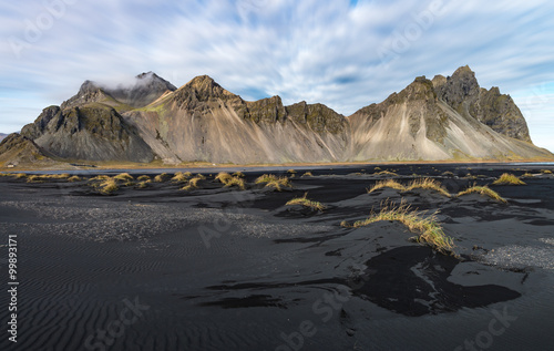 Black sand beach with mountain range background in sunny day Vesturhorn Iceland
