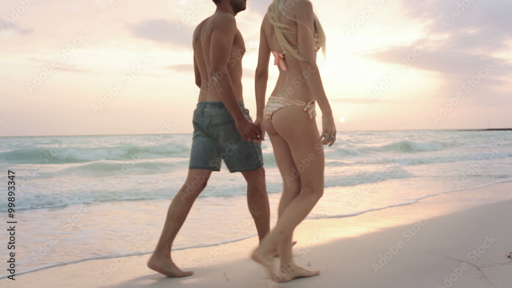 Back view couple walks along sea side gimbal steadicam Back view couple walks along sea side gimbal steadicam