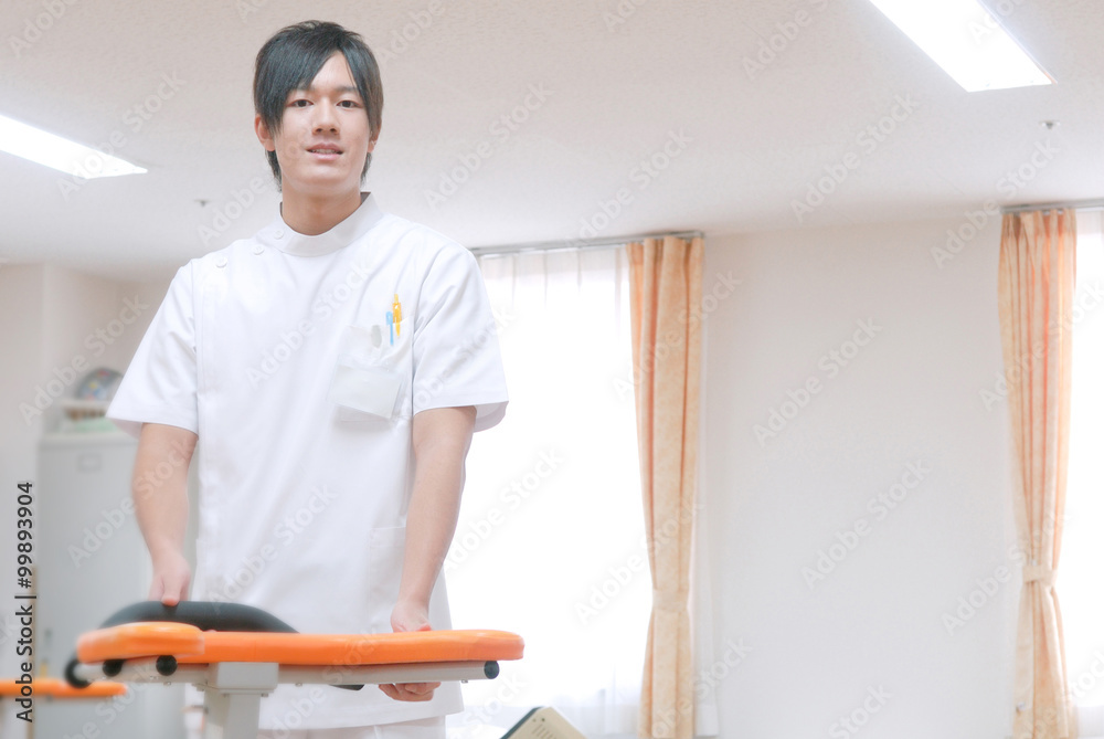 リハビリ室に立つ男性看護師