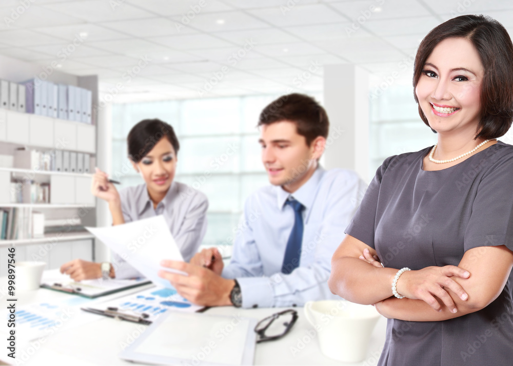 happy mature business women with her two staff behind happy mature business women with her two staff behind