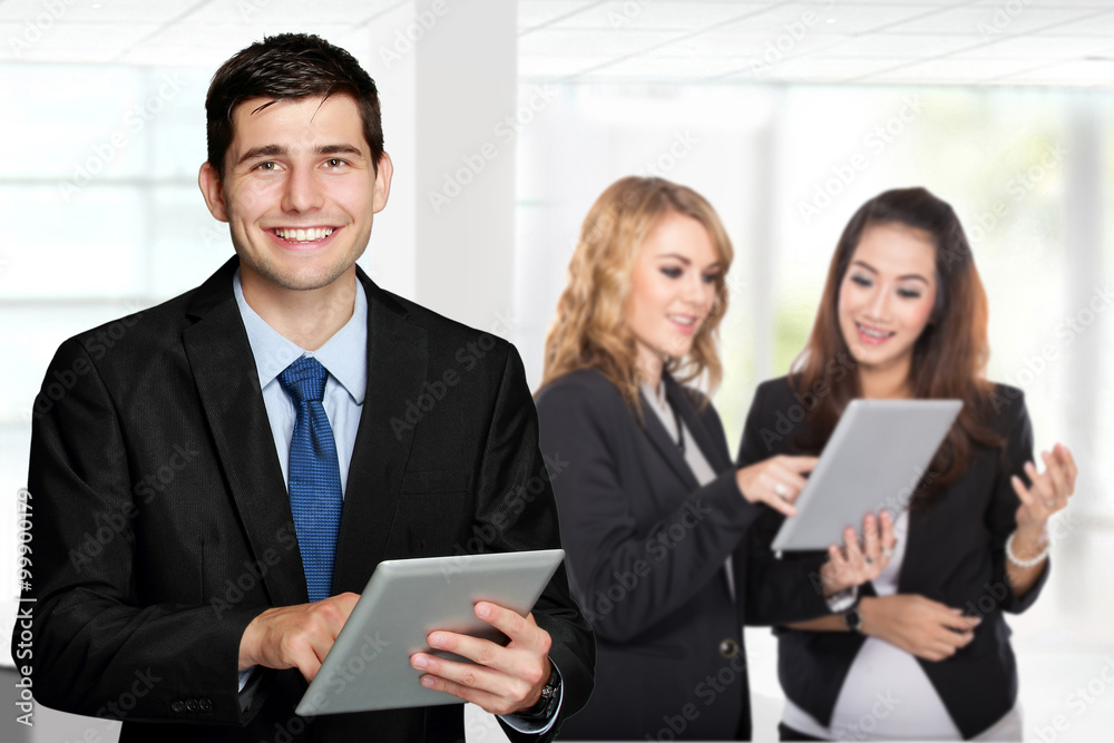 Young caucasian businessman, holding tablet pc. with his team Young caucasian businessman, holding tablet pc. with his team
