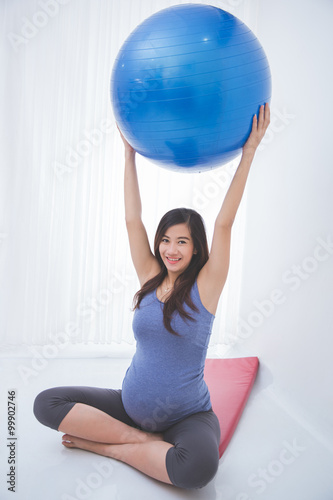 Beautiful asian pregnant woman doing exercise with a yoga ball,