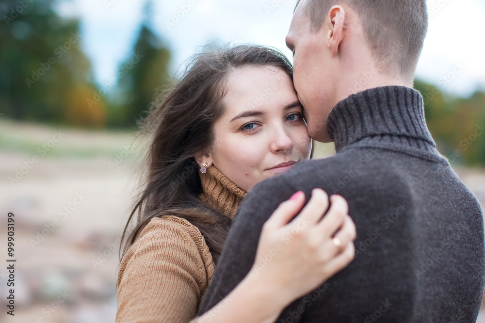 Young couple hugging on a rock on the beach Young couple hugging on a rock on the beach