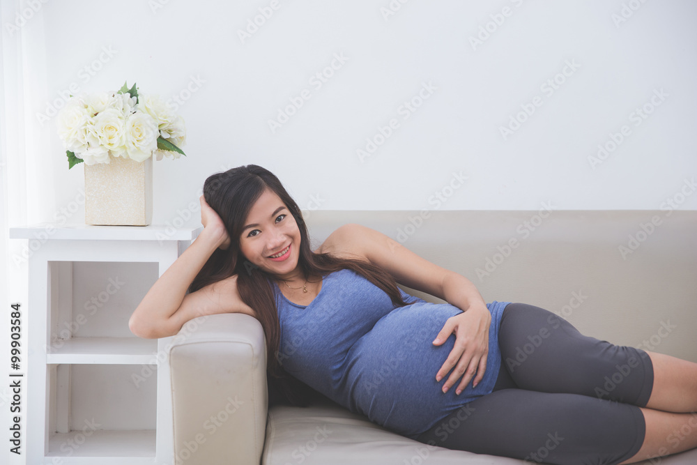 Beautiful Asian Pregnant woman laying on a couch Beautiful Asian Pregnant woman laying on a couch