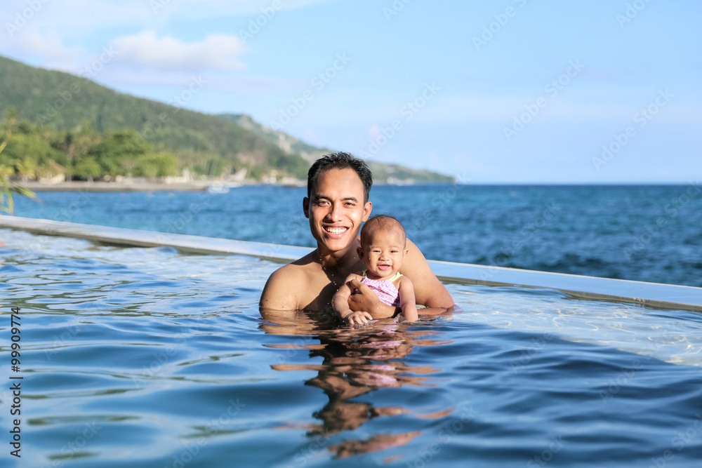 baby having fun in the swimming pool with mother