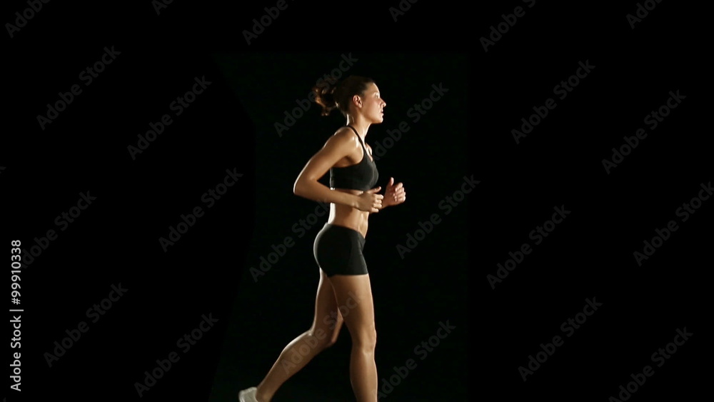 Woman is running on treadmill slow motion isolated on black Woman is running on treadmill slow motion isolated on black