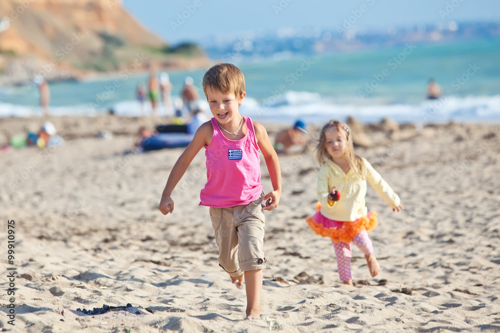 Happy kids are running on the beach 